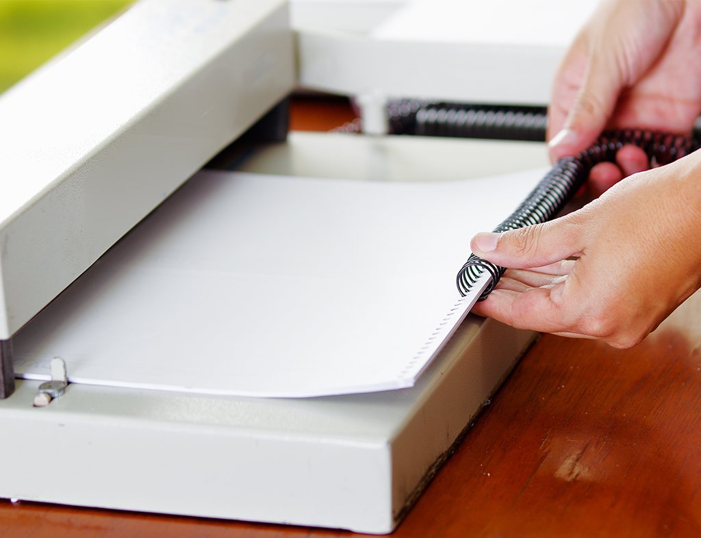 Image of a person binding a document with spirals